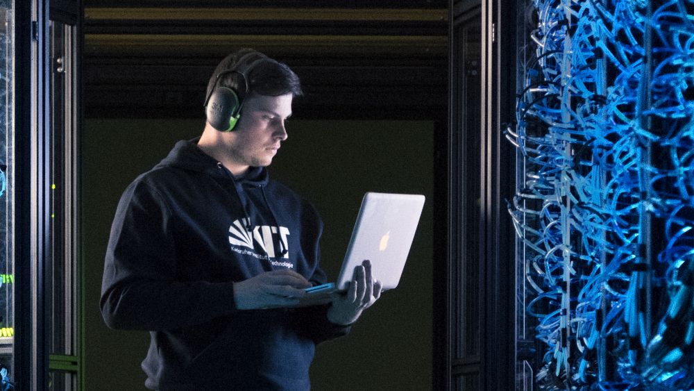 IT am KIT: IT-Spezialist arbeitet an Laptop in einem Serverraum.