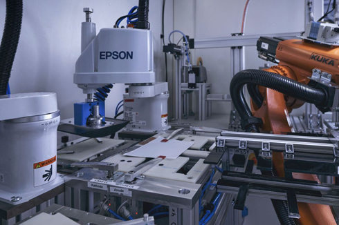 Innenansicht des SmartBatteryMakers mit zentralem Roboter und den drei Produktionsmodulen zum Stapeln (links), Kontaktieren (Mitte) und Verpacken (rechts).