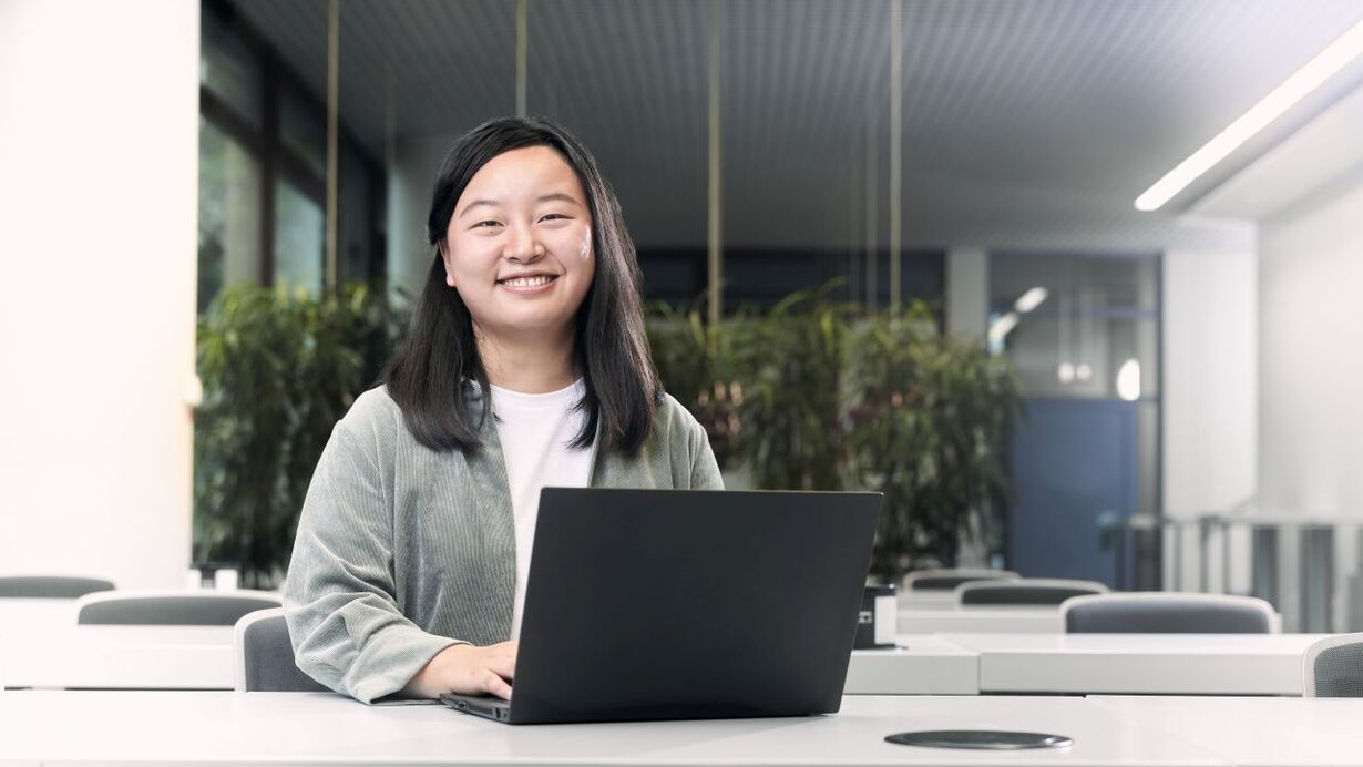 Eine junge Frau arbeitet am Laptop