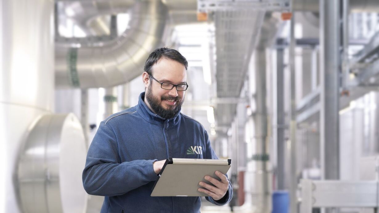 Ein technischer Mitarbeiter, im Hintergrund technische Gebäudeausrüstung