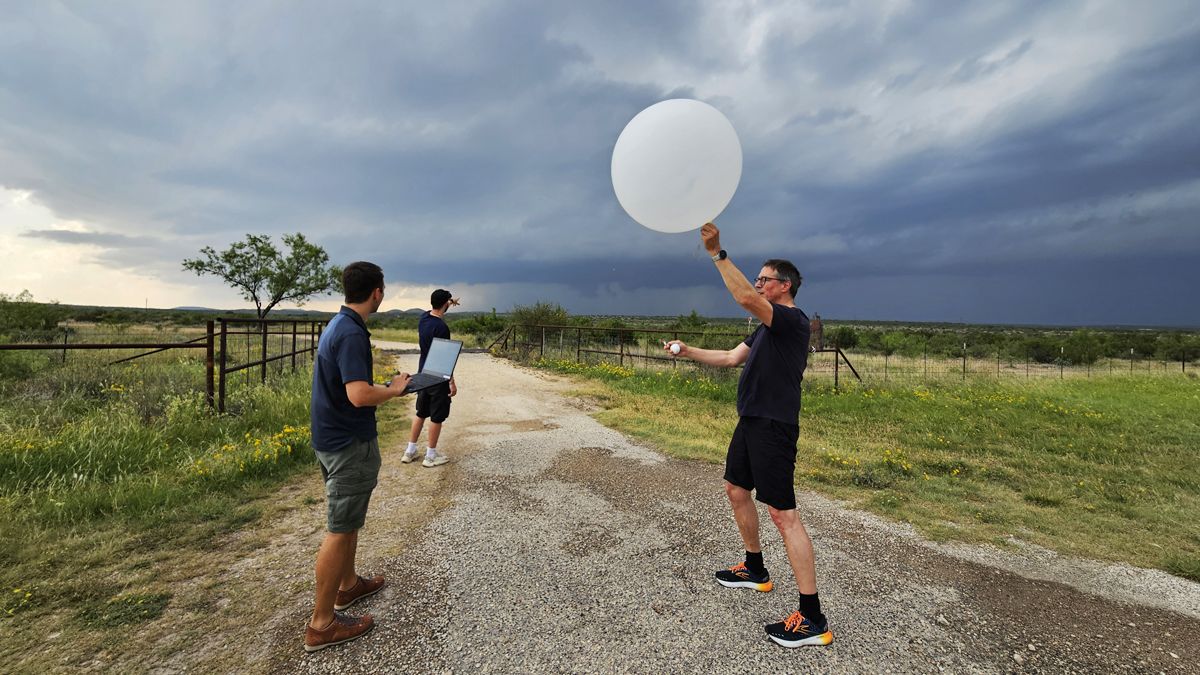 Wissenschaftler bei einer Feldmesskampagne in ländlicher Gegend vor Gewitterwolken: Prof. Kunz (rechts) lässt einen Ballon mit einer Hagelsonde steigen.