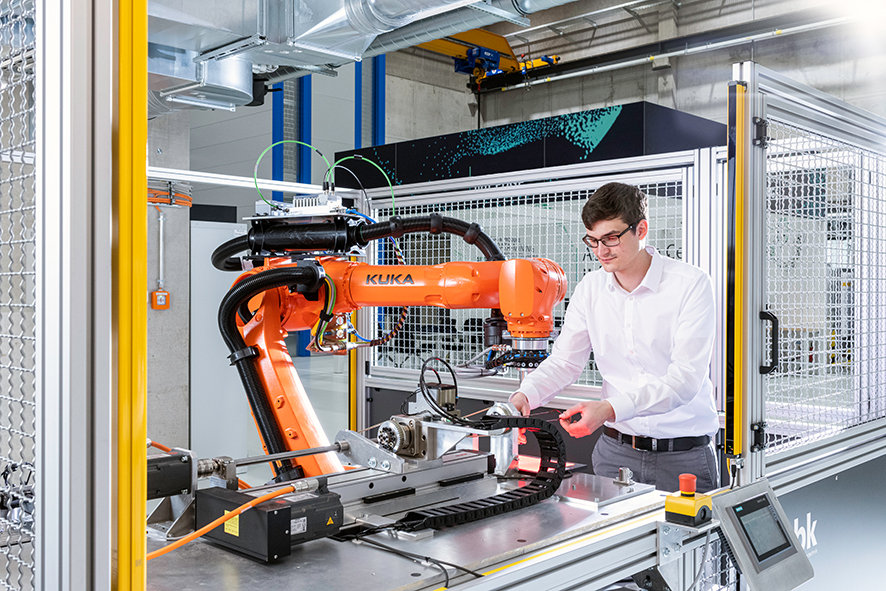 Foto einer Person arbeitend am Roboterarm