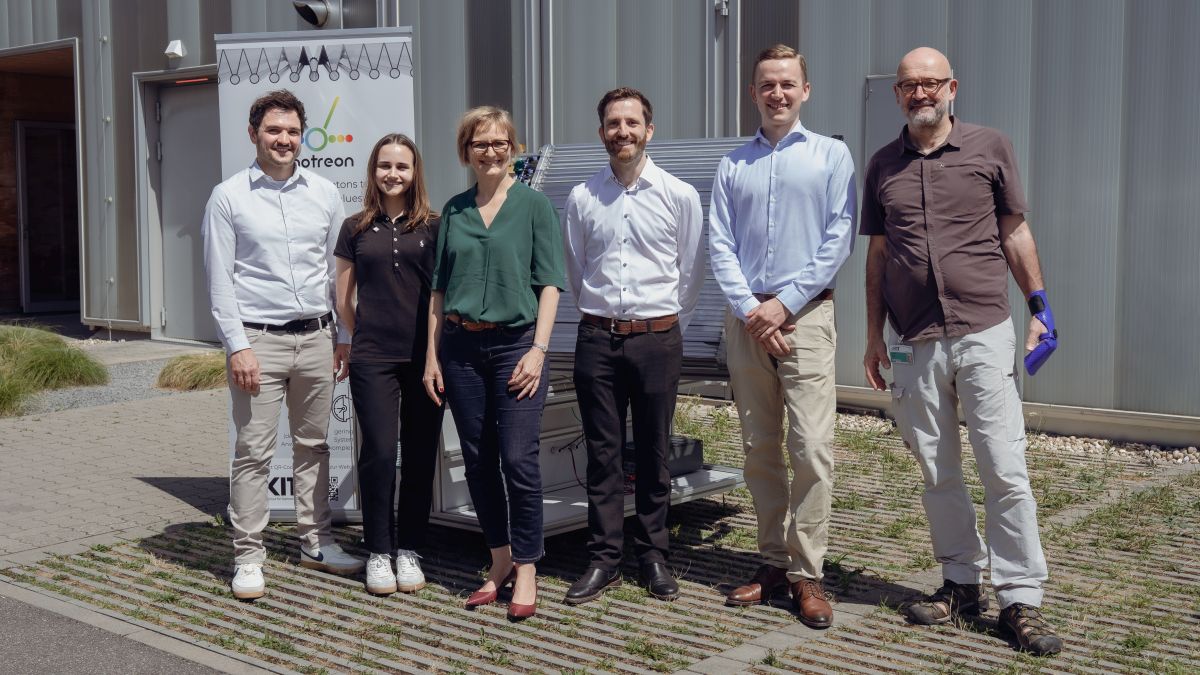Gruppenfoto des Besuchs vor einem Prototyp des photreon-Photoreaktorpaneels am Campus Nord.
