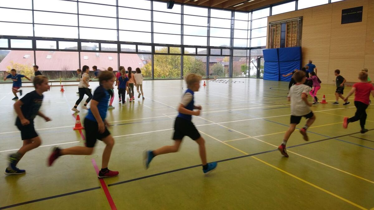 Eine Gruppe Kinder, die in einer Turnhalle Sport treibt