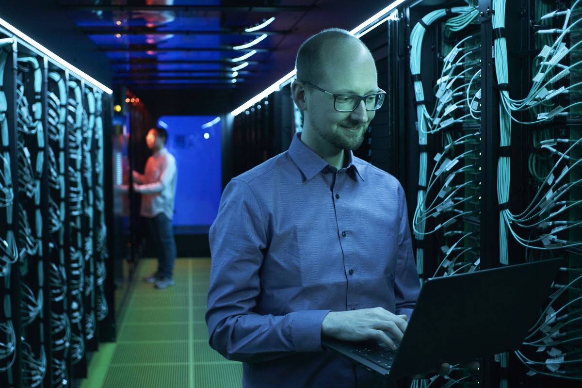 Pascale Friederich im Serverraum des Hochleistungsrechners Horeka am KIT. Ein Techniker arbeitet im Hintergrund.