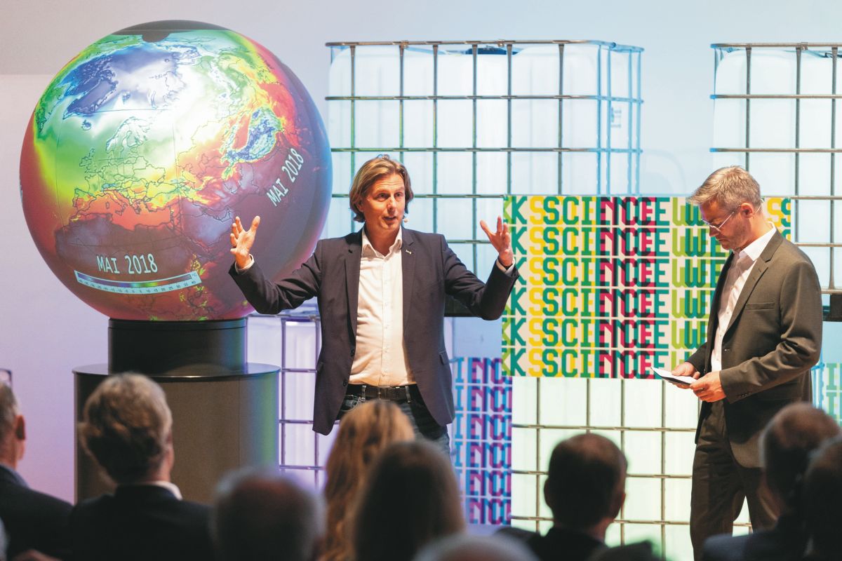 Ein Wissenschaftler hält einen Vortrag mithilfe eines großen Präsentationsglobus, der Klima-Zusammenhänge anschaulich macht.