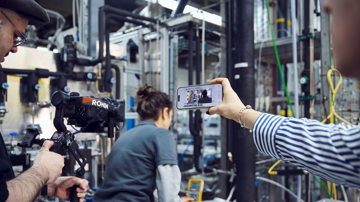 Dreharbeiten mit einer Wissenschaftlerin im Labor mit Smartphone und professioneller Kameraausrüstung