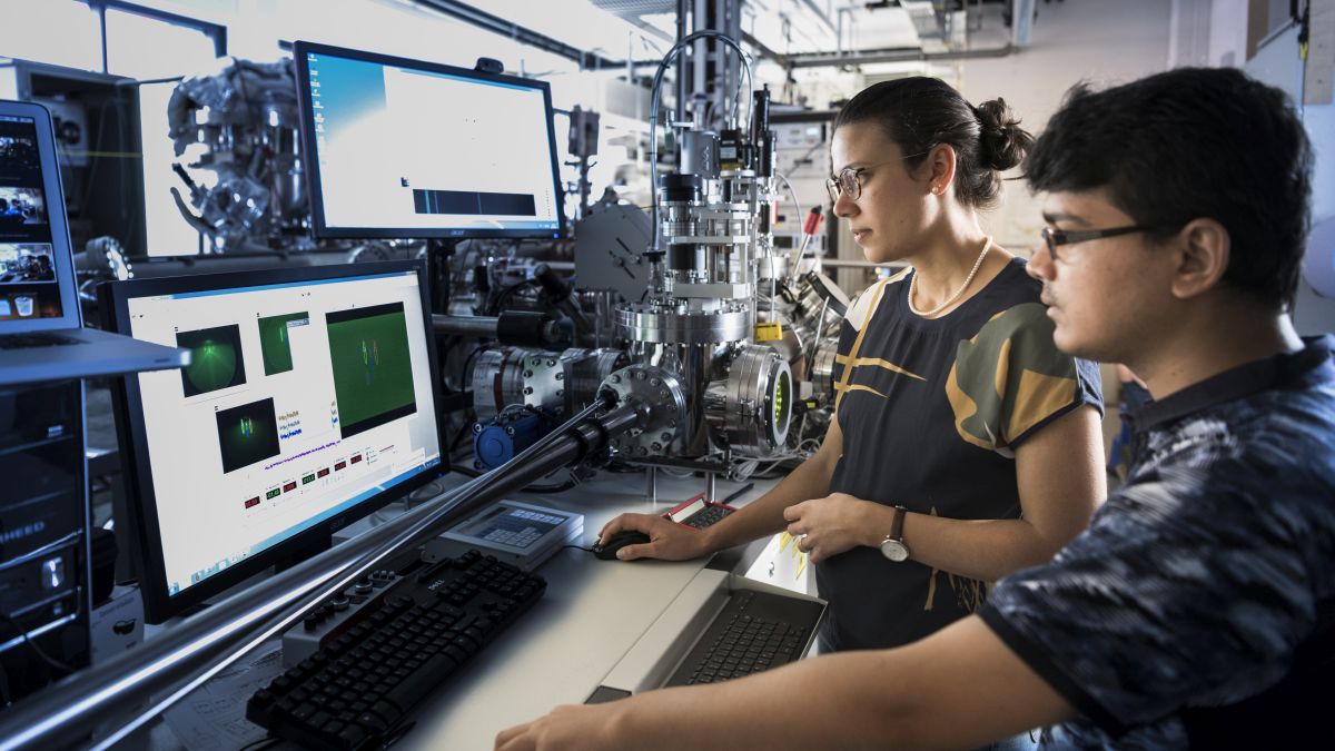 Zwei junge Forschende analysieren Daten in einem Labor.