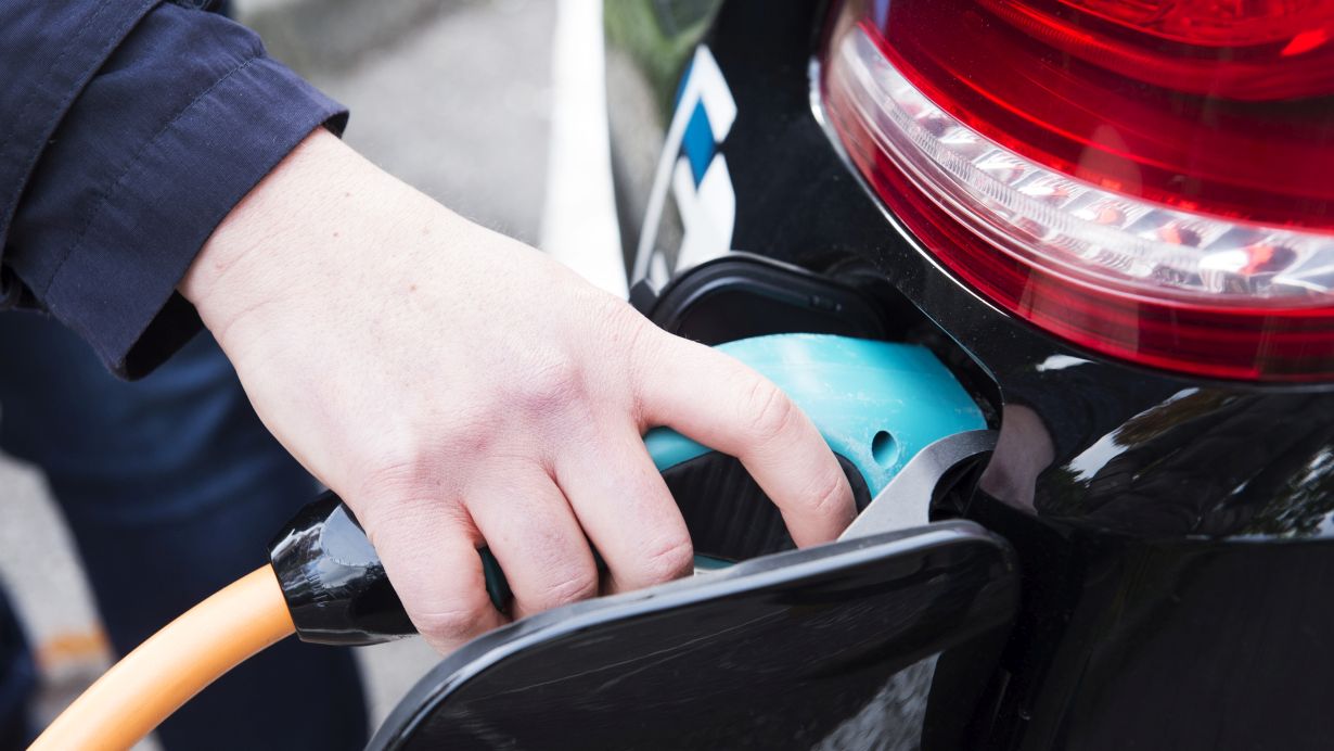 Sandra Goettisheim Hand, die ein Auto an ein E-Netz anschließt