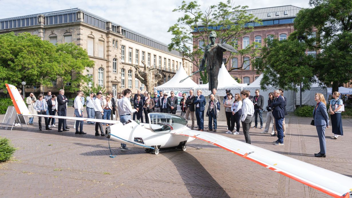 Besuchergruppe mit Flugzeug am KIT Tag der offenen Tuer