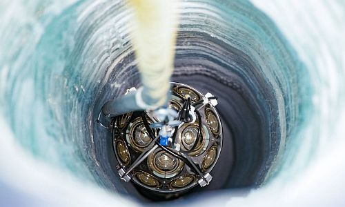 Die Ketten mit Instrumenten werden in die ins antarktische Eis gebohrten Sch&auml;chte eingelassen. (Bild: Yuya Makino, IceCube/NSF)