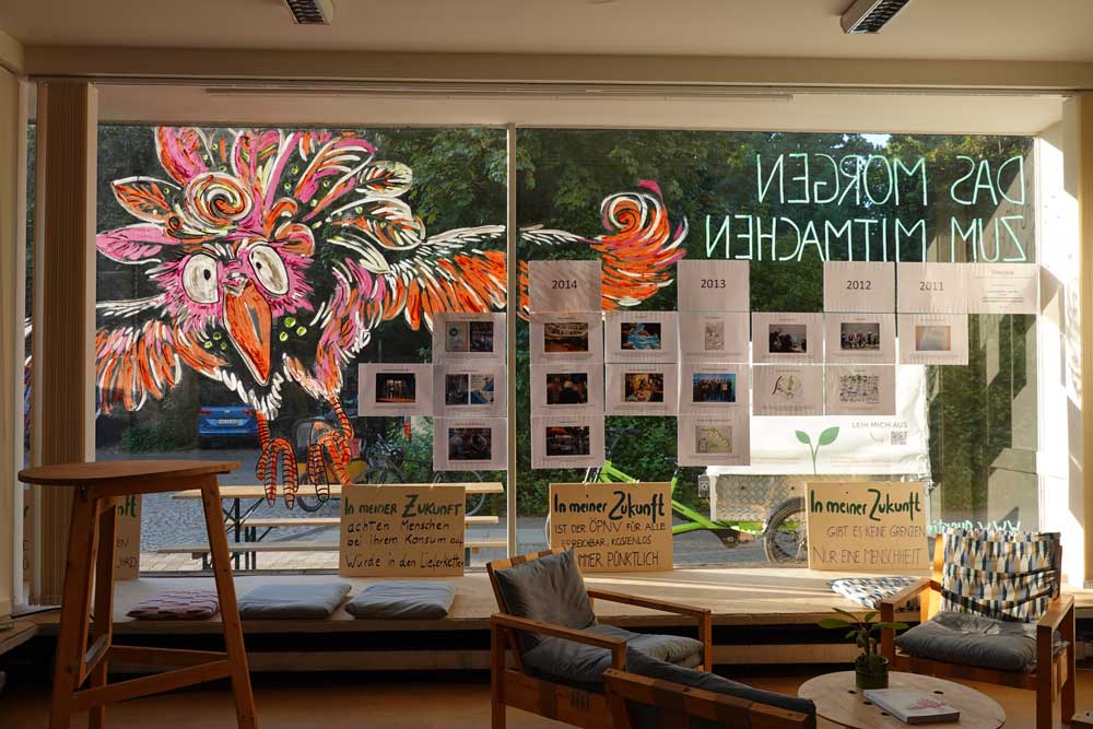 Die Schaufensterscheibe des Quartier Zukunft, mit Plakaten und Farbe geschmückt